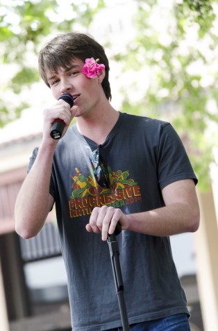 Patrick Collins, 21, dons a flower thrown to him by fans while singing at De Anza's Club Karaoke day in the main quad, Thursday April 17.
